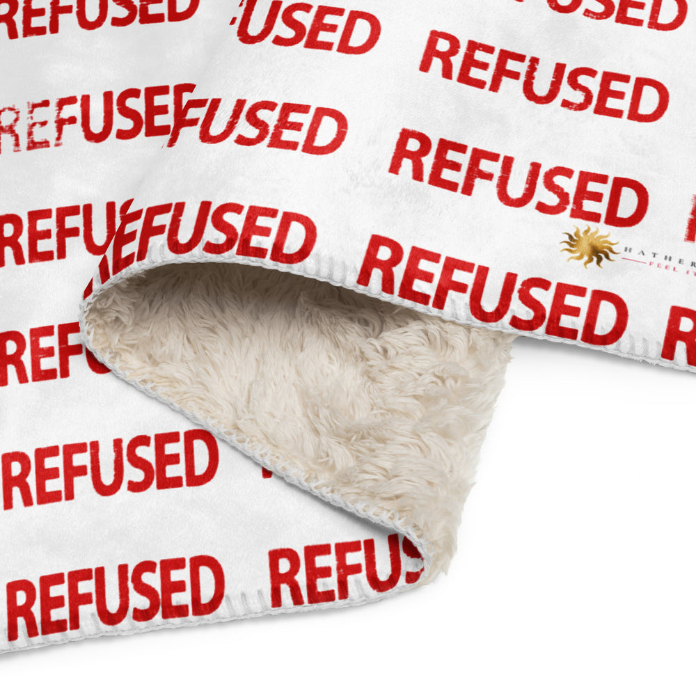 Close-up of the Refused sherpa blanket corner showing plush beige sherpa underside, soft microfiber face, neat edge stitching, and vivid red “REFUSED” print; emphasizes cozy texture and high-detail all-over design. Artwork and design by Nicholas Hayes, a Chicago based optical art artist.