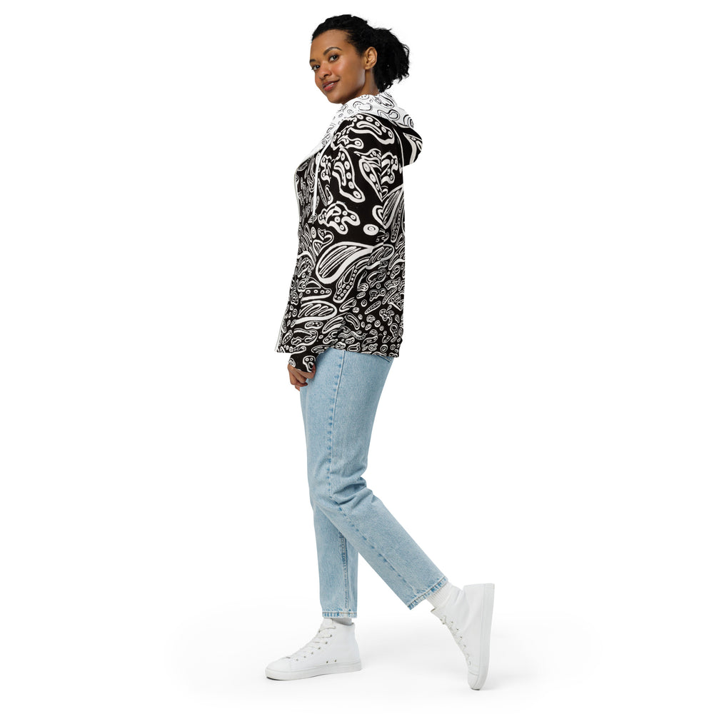 Three-quarter front angle highlighting seamless wraparound Penumbra artwork across chest and sleeves; relaxed drop-shoulder cut, soft cotton-feel exterior, and cozy brushed-fleece interior for everyday wearable art. The black hoodie with white shapes all over that look like floating cells was designed by Nicholas Hayes.