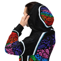 Side view on model wearing Penumbra Painting No. 2 hoodie, emphasizing drop-shoulder relaxed fit, sleeve length, and continuous abstract pattern flowing from chest to arm. Abstract shapes flow all over the sweater in rainbow colors. 