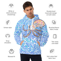 a man wearing a blue and white hoodie of an octopus.  the hoodie is made of colorful shapes of blue and white for water.  the octopus is black, red, and orange. there are words that describe the hoodie - relaxed fit, drop shoulders, unisex style, tear away care label, double-lined hood with design on both sides, white or black premium drawstrings, soft cotton-feel fabric face, brushed fleece fabric inside. 