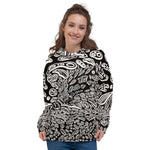 Model front view wearing a black hoodie with trippy white shapes that look like cells by Nicholas Hayes. Unisex relaxed fit with kangaroo pocket, drawstring hood, and black-and-white abstract all-over print; soft cotton-feel face and brushed-fleece lining.