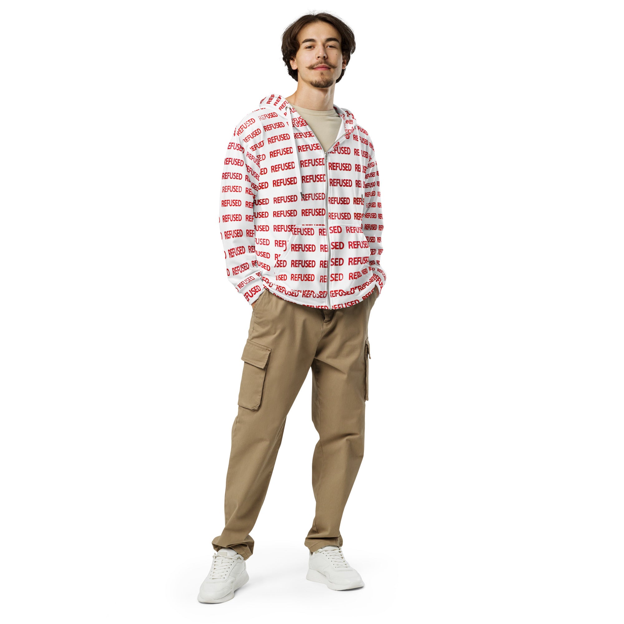 a white male in his 20's standing wearing a white zip hoodie with the word REFUSED printed across the entire jacket in a pattern.  Detail of the premium front zipper and roomy pockets on the Refused zip hoodie; highlights smooth hardware, relaxed fit, and brushed-fleece lining that adds warmth without bulk, ideal for daily wear.  design by Chicago based artist Nicholas Hayes.