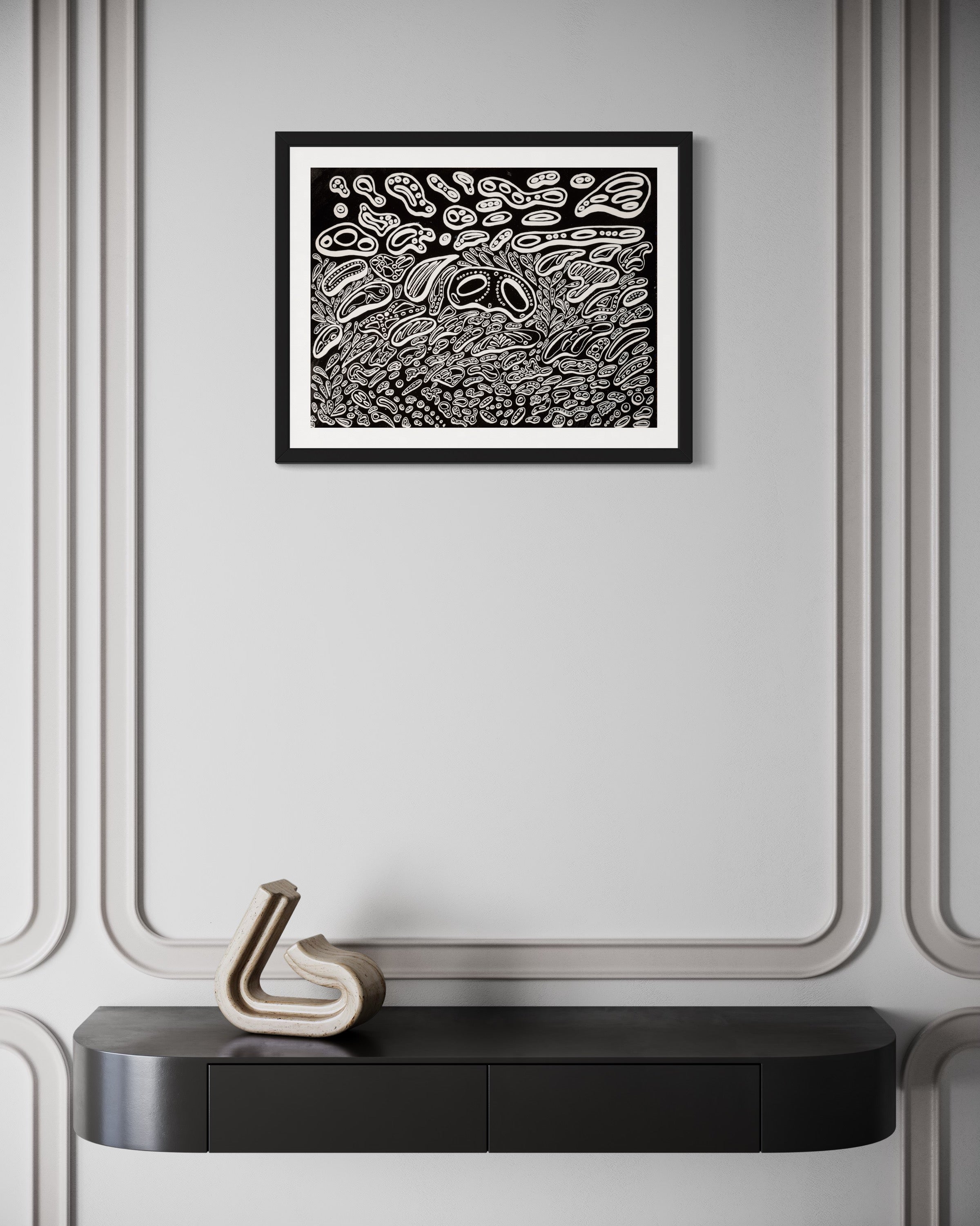 A framed abstract painting hanging on a wall above a decorative console table, with black and white colors predominating. Front view of ‘Penumbra Painting No. 1’ by Nicholas Hayes. Original 18×24 acrylic on heavyweight canvas paper, professionally framed, one-of-a-kind artwork ready to hang; contemporary statement piece for modern home or gallery walls.