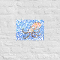 Print displayed on white brick wall: “The Octopus” fine art print by Nicholas Hayes. Trippy psychedelic octopus with blue abstract water shapes; 12×16 inches on museum-quality matte paper, ideal ocean art focal point for contemporary interiors.